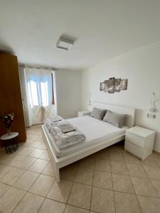 a bedroom with a large white bed in a room at Casa Piccola in Tremosine Sul Garda