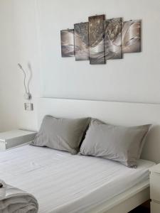 a bedroom with a bed with four paintings on the wall at Casa Piccola in Tremosine Sul Garda +1 photo