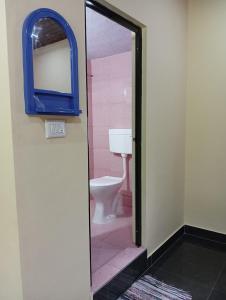 ein Badezimmer mit Toilette und Spiegel in der Unterkunft TungaTeera Homestay in Sringeri