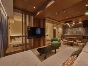 a living room with a television and a dining room at illi Aest Shinagawa-Gotanda in Tokyo