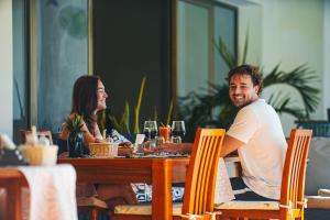 a man and woman sitting at a table at Seaclusion Diani in Diani Beach