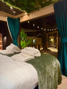 two beds with white pillows and a green blanket at The Secret Garden Glamping Cornwall in Cury +144 photos