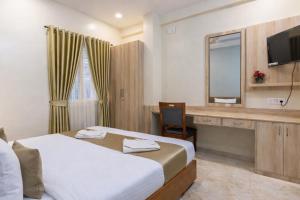 a hotel room with a bed and a desk with a mirror at Hotel Chalet, Madiwala in Bangalore +8 photos