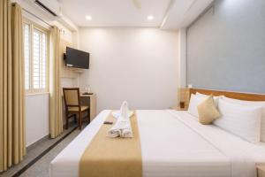 a hotel room with a bed and a tv at Hotel Chalet, Madiwala in Bangalore
