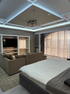 a bedroom with a large bed and a living room at Hotel Panorama in Dushanbe
