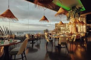 a restaurant with tables and chairs and a large window at Villas Elements by Alondra in Puerto del Carmen