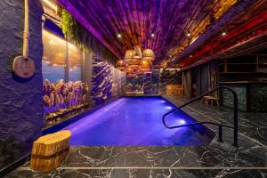 a lap pool in a room with purple lighting at Agate Resort & SPA in Mykulychyn +51 photos