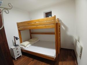 a wooden bunk bed in a room with a night stand at Apartamenty Polonia in Cserépfalu