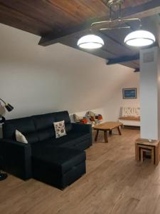 a living room with a black couch and a table at Apartamenty Polonia in Cserépfalu