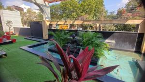 a garden with a swimming pool and a fountain at Hotel Sriram JB Residency in Virudunagar
