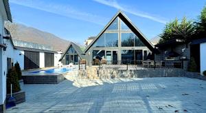 a house with a large window and a swimming pool at Black A-Frame Luxury Chalet & Pool in Gabala
