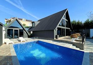 a swimming pool in front of a house at Black A-Frame Luxury Chalet & Pool in Gabala
