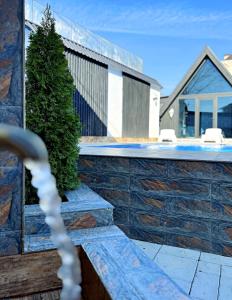 a house with a swimming pool and a tree at Black A-Frame Luxury Chalet & Pool in Gabala