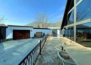 a deck with a table and chairs on a building at Black A-Frame Luxury Chalet & Pool in Gabala