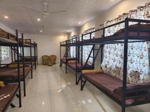 a room with bunk beds in a dorm room at The Rishi Van Dormitory, Khetri,Rajasthan,Farm No 52-55,Vally Drive,Retreat Nature Farms Society Complex in Khetri