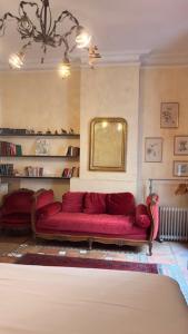a living room with a red couch and a mirror at Bartissol et Maillol in Perpignan