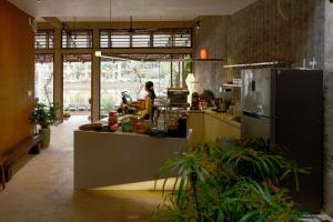 a woman standing behind a counter in a kitchen at Amea Homestay in Thôn Kim Long (1) +93 photos