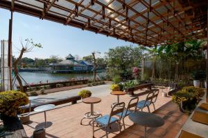 a patio with tables and chairs and a view of the water at Amea Homestay in Thôn Kim Long (1)