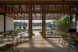 a patio with tables and chairs and a view of a river at Amea Homestay in Thôn Kim Long (1)