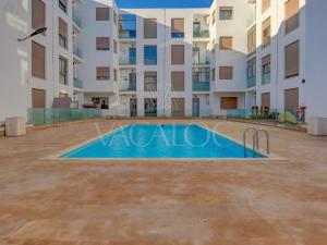 a swimming pool in front of a building at Iris Agadir - Luxe - Piscine - 4 Px in Agadir
