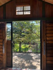 an open door to a patio with a tree at The Forester Chalet in Buôn Pưk Prong