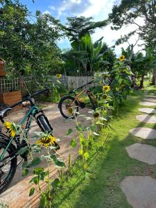 two bikes parked in a garden with flowers at The Forester Chalet in Buôn Pưk Prong