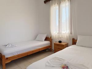 a bedroom with two beds and a window at Xenius Zeus Apartments in Kriopigi in Kriopigi