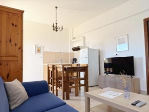 a living room with a blue couch and a table at Xenius Zeus Apartments in Kriopigi in Kriopigi