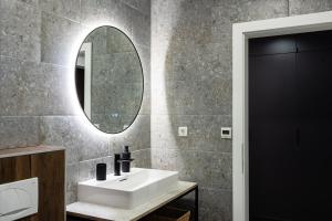 a bathroom with a white sink and a mirror at The Hill Aparthotel in Mostar +62 photos