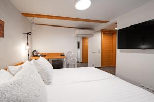 a bedroom with two beds and a flat screen tv at Rixwell Old Riga Palace Hotel in Riga