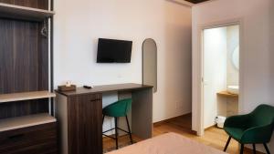 a bedroom with a desk and a green chair at Al Duomo Suites in Monreale