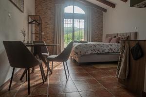 a bedroom with a bed and a table and chairs at Cortijo el Sendero in Alora