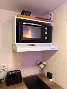 a microwave sitting on a shelf in a kitchen at L'Interdite House - Limitless - Jacuzzi Cinema Love in Savigny-sur-Orge