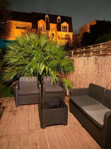 a patio with two couches and a potted plant at L'Interdite House - Limitless - Jacuzzi Cinema Love in Savigny-sur-Orge