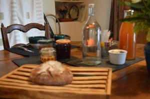 a table with a bottle and a bagel on it at Chambre d'hôtes La Folie in Vouhé