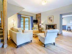 a living room with two chairs and a fireplace at East Lodge in Falkland