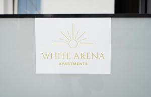 a sign for white arena apartmentments on a window at White Arena Apartments GOLEM in Golem