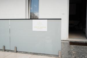 a sign on the side of a building at White Arena Apartments GOLEM in Golem +84 photos