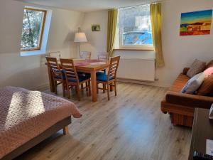 a living room with a table and chairs and a couch at Sielanka pod Siglanami 2 in Wisła