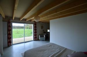 a bedroom with a bed and a large sliding glass door at Chambre d'hôtes La Folie in Vouhé