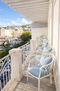 eine Reihe Stühle auf einem Balkon in der Unterkunft Grand Hôtel d'Espagne in Lourdes