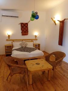 a bedroom with a bed and a table and a bed at Kfar Hanokdim - Desert Guest Rooms in Arad