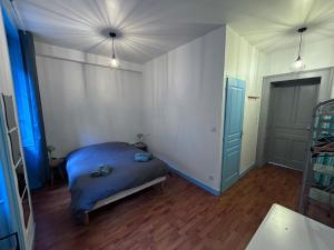 a bedroom with a bed and a room with blue doors at L azur Jurassien séjour chaleureux dans le Jura in Saint-Claude