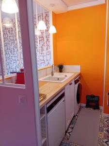 a kitchen with a sink and a washing machine at La parenthèse 70's in Le Havre