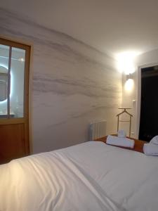 a bedroom with a large white bed and a window at La parenthèse 70's in Le Havre