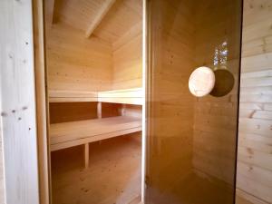 a wooden sauna with a light on the wall at Camping Héiltzerstee in Rambrouch