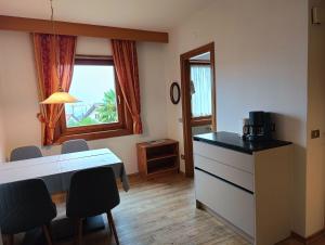 a kitchen with a desk and a table and chairs at Ferienwohnungen St Hippolyt mit Hallenbad in Lagundo
