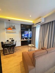 a living room with a couch and a table and a television at J5 Hotel in Ban Zong Katiam