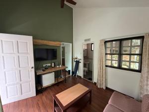 a living room with a desk and a television at Perkasa Hotel Mt Kinabalu in Kampong Kundassan