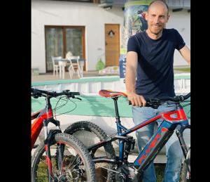 a man is standing next to two bikes at B&B La barca ant al prà in Cuneo